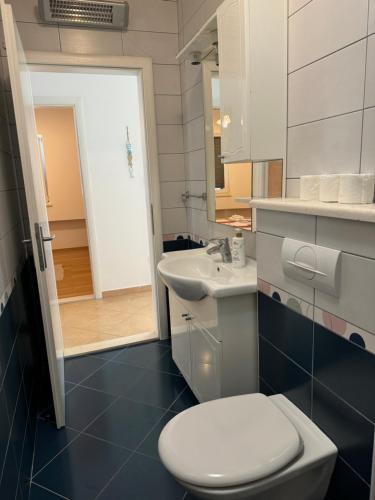 a bathroom with a white toilet and a sink at 2 bed Comfy Gem: Functional, Ideal Location, Steps to the Beach in Blace