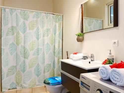 a bathroom with a shower curtain and a toilet at Breathtaking Bora Bora Lagoon View Studio in Bora Bora