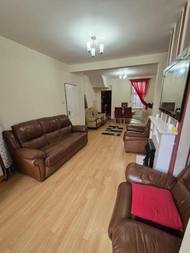 a living room with leather couches and a fireplace at Hanna house in Belfast