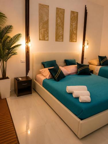 a bedroom with a bed with towels on it at Monolocale elegante con design moderno e atmosfera tropical chic in Nardò