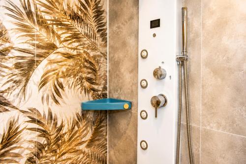 a shower with a white door with a palm tree mural at Monolocale elegante con design moderno e atmosfera tropical chic in Nardò