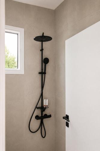 a bathroom with a stand up shower with a shelf at Elichri Theros Studios in Katelios