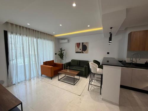 a kitchen and living room with a couch and a table at Luxueux T2 à Ain Zaghouen in El Aouina