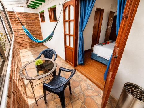 a room with a hammock and a table and chairs at Roomii Hostel in Villa de Leyva