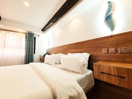 a bedroom with two beds and a wooden wall at Brooks Lodge in Nakuru