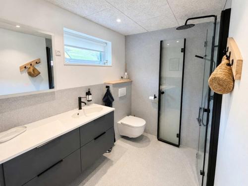 a bathroom with a sink and a toilet and a shower at Hvanngarðs Smáttan by Stóra in Dalur