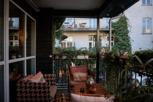 a patio with a chair and a table on a balcony at 66 Guldsmeden in Copenhagen