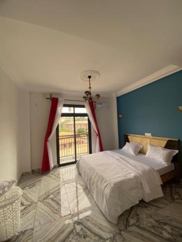 a bedroom with a large bed and a window at Lita résidence in Yaoundé