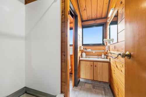 a bathroom in a tiny house with a sink at Orewa Motor Lodge in Orewa