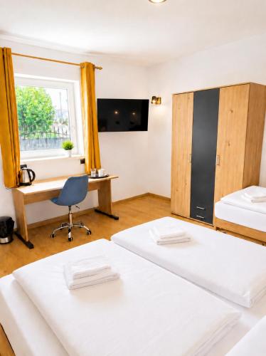 a room with two beds and a desk and a window at M3-Apartmány in Martin