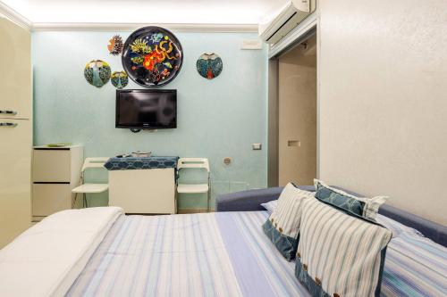 a bedroom with a bed and a tv on the wall at Sea 150mt - Il Vicolo di Cetara in Cetara