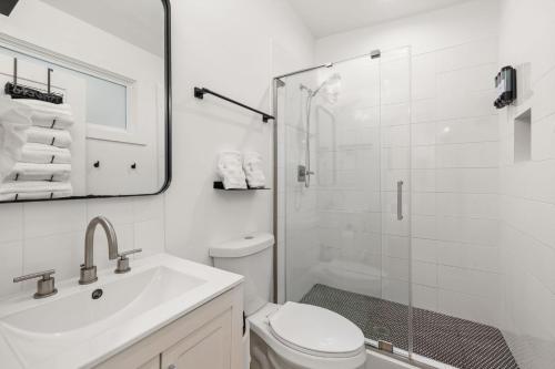 a white bathroom with a shower and a toilet at Irie Vibes Private Guest House Downtown in Raleigh