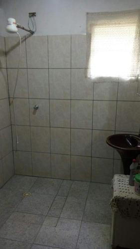 a bathroom with a shower with a window and a sink at Chácara chalé in Juquitiba