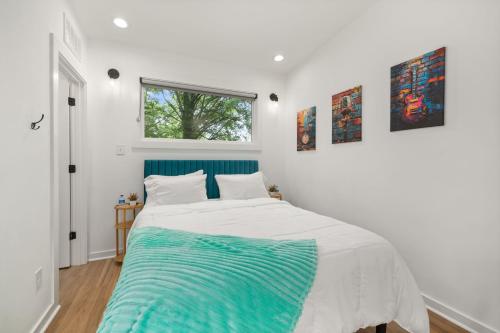 a white bedroom with a bed and a window at Irie Vibes Private Guest House Downtown in Raleigh