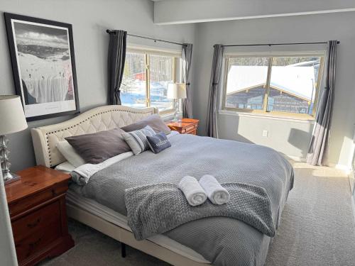 a bedroom with a bed with two towels on it at 2 Bedroom Mountain View Condo with Private Hottub in Girdwood