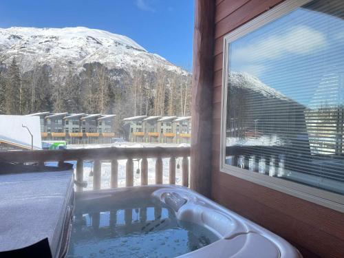 a hot tub on a balcony with a view of a mountain at 2 Bedroom Mountain View Condo with Private Hottub in Girdwood