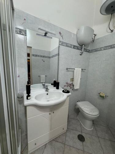 a white bathroom with a sink and a toilet at La Dimora di Zia Rosa in Crotone