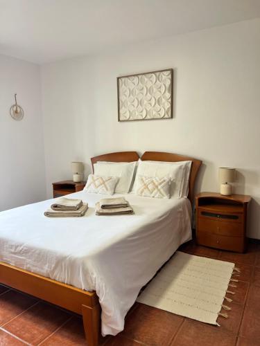 a bedroom with a large bed with white sheets and pillows at Meu Quintal 1, Calheta-Madeira in Calheta
