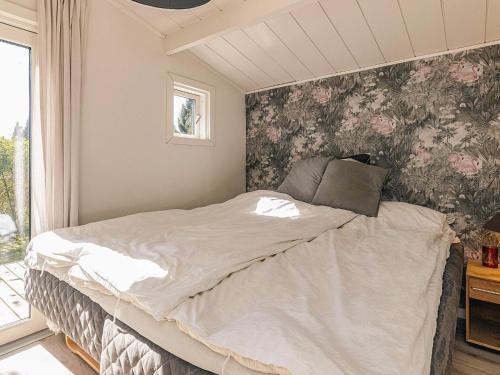 a bedroom with a bed with a floral wallpaper at 4 star holiday home in Græsted in Græsted