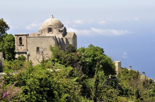 stary budynek na szczycie wzgórza z drzewami w obiekcie Appartamentino Pomelia w mieście Erice