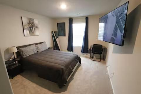 a bedroom with a bed and a flat screen tv at Modern Living, Close to Everything in Houston
