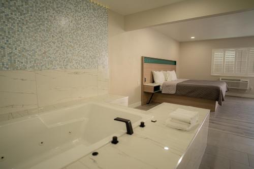 a bathroom with a bath tub and a bed at Flamingo Motel near Universal Studios in North Hollywood