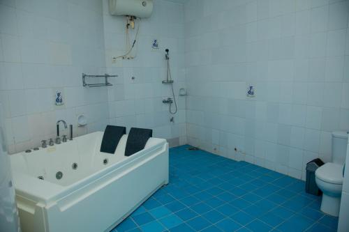 a white bathroom with a tub and a toilet at Atlantic Beach Hôtel Bénin in Cotonou