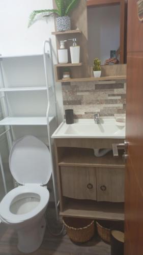 a bathroom with a white toilet and a sink at Veraniega in Playa Hermosa
