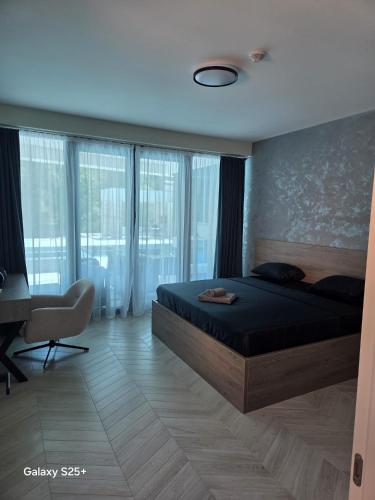 a bedroom with a bed and a desk and windows at The Bunica Residence in Parila