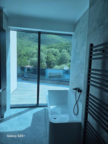 a bathroom with a bath tub and a large window at The Bunica Residence in Parila