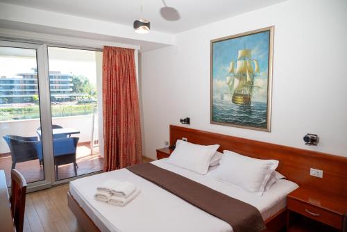 a bedroom with a large bed and a balcony at Hotel Porto A in Ulcinj