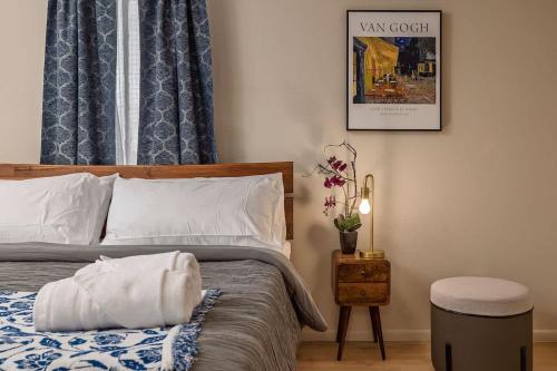 a bedroom with a bed with a night stand and a picture at Spacious King Historic Art Deco Studio in Anchorage