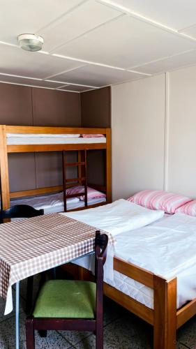 a bedroom with two bunk beds and a table at Šiška Kemp in Doksy