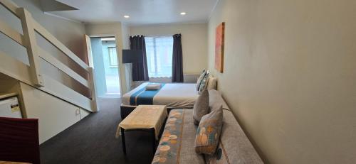 a hotel room with two beds and a couch at Baden Lodge Motel - PRIVATE SPA Bath in Rotorua