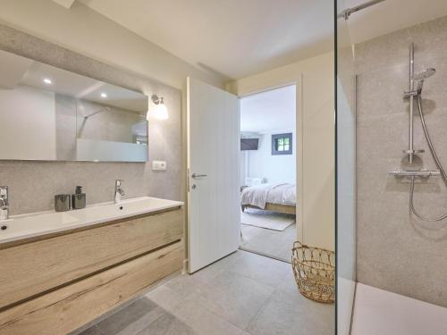 a bathroom with a tub and a sink and a bed at Rosselaer in Balen