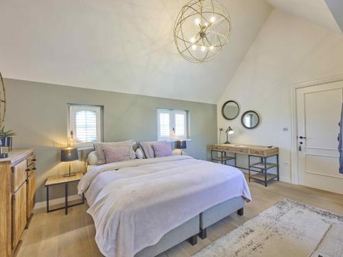a bedroom with a large bed and a chandelier at Rosselaer in Balen