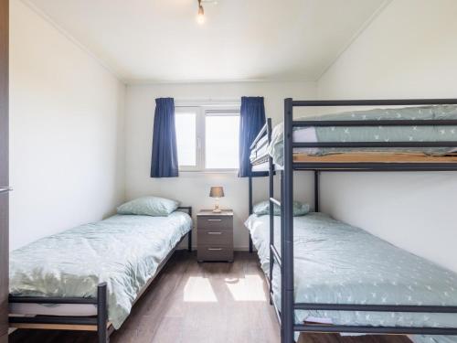 a bedroom with two bunk beds and a window at Sluisje 55 in Kuinre