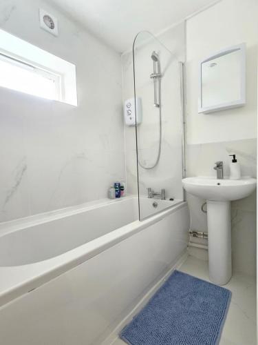 a white bathroom with a shower and a sink at Flat In City Centre in Cambridge