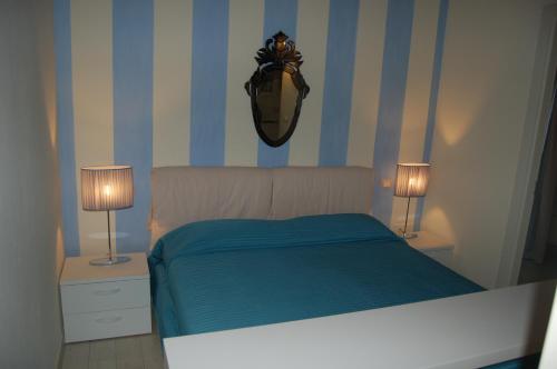een slaapkamer met een bed met blauwe en witte strepen bij Sonomusica B&B in Gazzola Di Rivalta