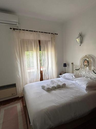 a bedroom with a white bed with towels on it at Casa dos Cândidos in Alagoa