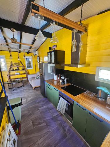 a kitchen with yellow walls and green cabinets at Bungalow Sugarcane in Saint-Louis