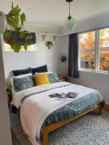 a bedroom with a bed and two windows at Right Side in Greytown