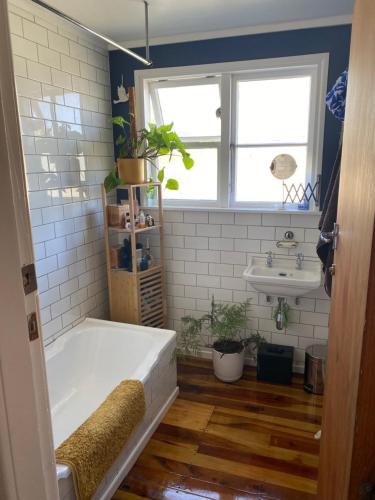 a bathroom with a tub and a sink at Right Side in Greytown