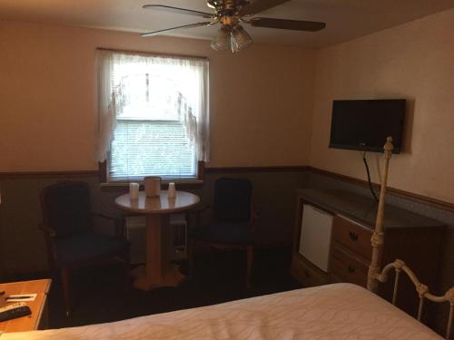 a bedroom with a bed and a tv and a window at Catalina Island Seacrest Inn in Avalon