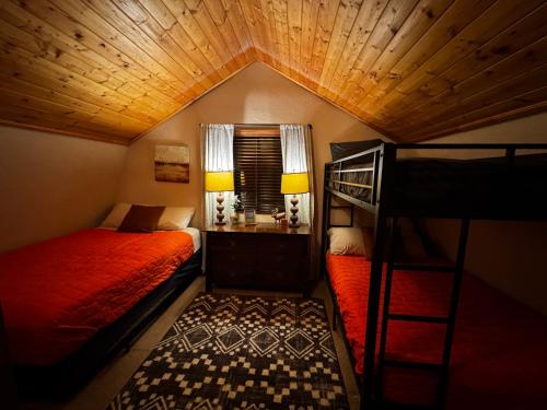 a bedroom with two bunk beds and a window at Covered Hot Tub Getaway Sleeps 9 in Duck Creek Village