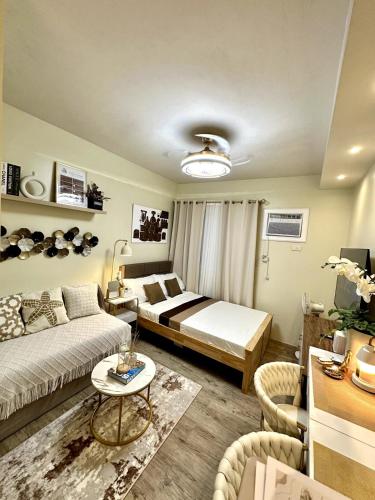 a living room with a bed and a couch at Atelier Studio, Stanford Suites 3, Silang in Silang