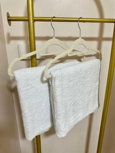 two white towels are hanging on a towel rack at Atelier Studio, Stanford Suites 3, Silang in Silang