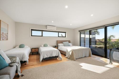 a room with three beds and a couch at The Islander in Ventnor