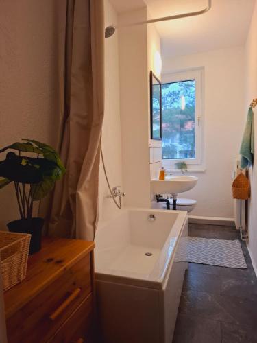 a bathroom with a white tub and a sink at Lua Beleza - 4 Bett Apartment Geiseltalsee in Mücheln