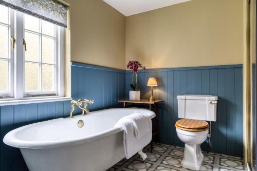 a bathroom with a white tub and a toilet at Roft Bank Cottage in Oswestry